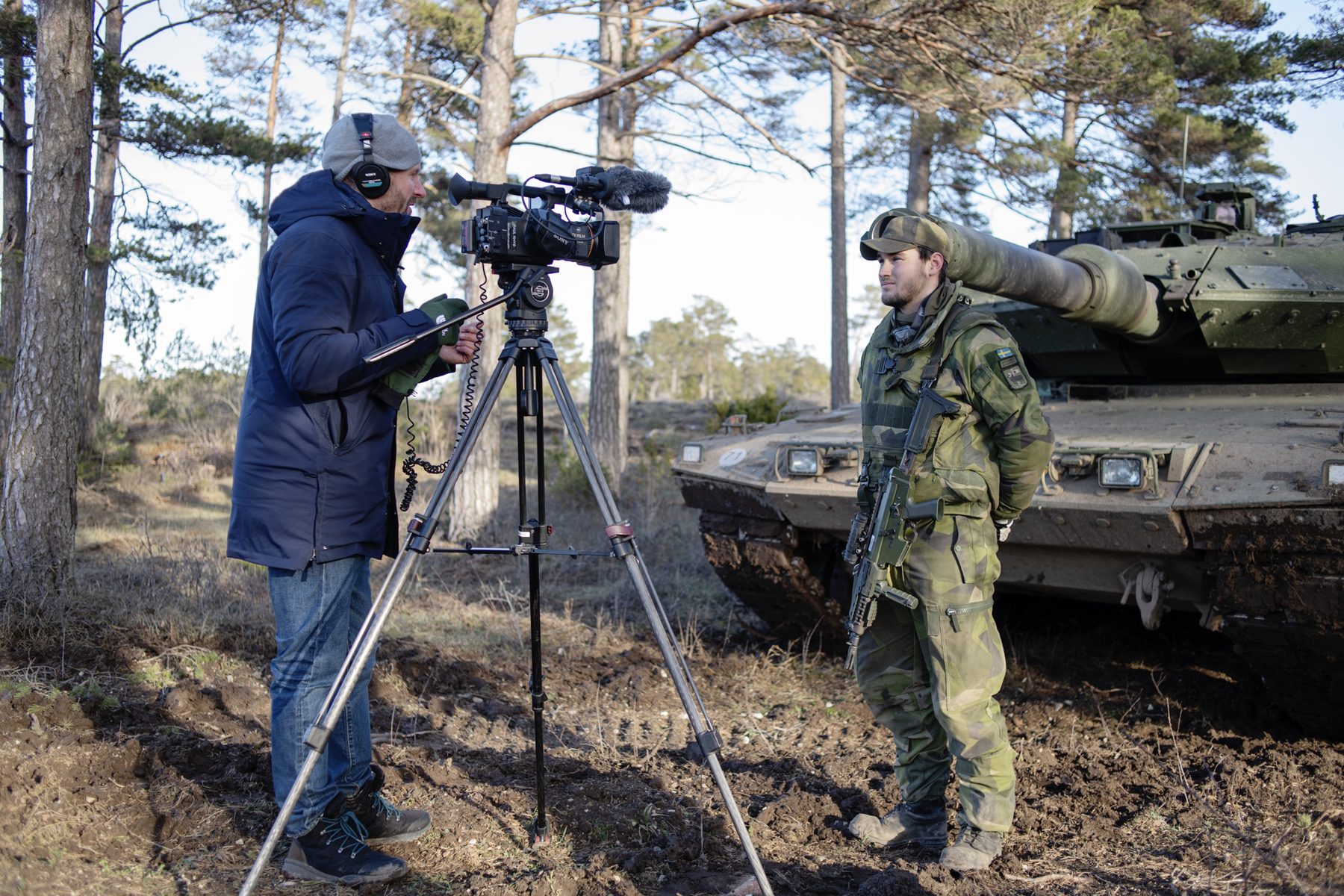 Paul Rhys filming a Swedish conscript beside a tank on Gotland